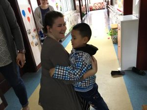 Saint Vincent student hugging child at Children Welfare Institute