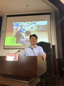 Dr. Li smiling at podium